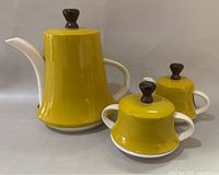 Front view of teapot, creamer and sugar bowl with lids attached