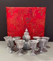 Full set arranged in front of closed brocade case