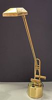 Full view of brass swing-arm desk lamp showing overall form