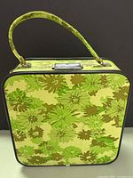 Front view of green floral vinyl suitcase