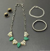 All four jewelry items laid out: necklace, two bracelets, earrings