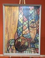 Full view of framed painting on easel