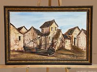 Framed village scene painting with boat