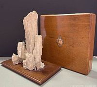 Mounted natural rock specimen beside closed wooden document box