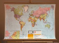 Full view of hanging world map scroll on easel