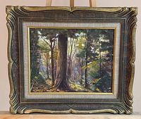 Full view of framed forest painting on easel