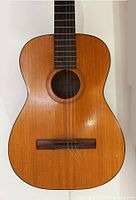 Close-up of guitar body highlighting wood grain, soundhole label and bridge