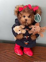 Front view of plush bear with raincoat, boots, mini plush animals
