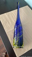 Full view of tall blue blown glass bottle