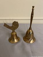 Both brass hand bells side by side