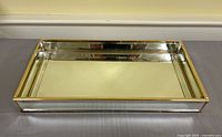 Rectangular brass-framed mirrored tray on surface