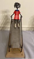 Front view of metal girl on slide sculpture