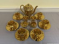 Full set arranged showing teapot, six cup-saucer sets, sugar bowl and creamer