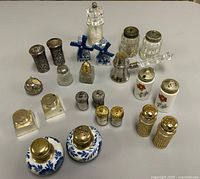 Group shot of twenty-two assorted mini salt and pepper shakers in various materials and designs