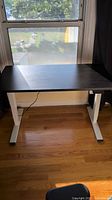 Desk lowered showing black top and white frame