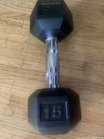 Side view showing full dumbbell, hex heads, knurled handle, 15 lb marking