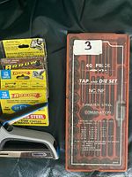 Staple boxes beside closed 40-piece tap and die set case