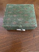 Closed green brocade box with loop and toggle clasp