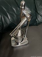 Front three-quarter view of assembled stainless steel hand juicer
