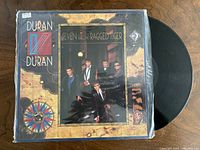 Front of outer sleeve with vinyl partially removed, shows album art and record condition