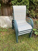Front view of stacked green metal patio chairs