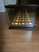 Front view of wood-framed glass infinity candle box showing multiple reflected tealights