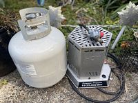 Propane tank next to portable heater showing overall lot