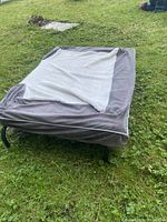 Elevated dog bed with fleece cover placed on grass