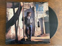 Front jacket with partial view of black vinyl disc