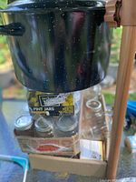 Overall lot with enamel pot atop shrink-wrapped jars and boxed jars visible