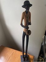 Full view of wooden jazz player statue front angle