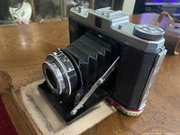 Camera in open position showing bellows and lens