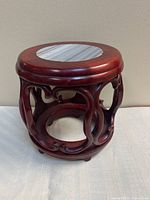 overall view of carved hardwood stand showing marble inset top and openwork design