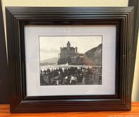 Full view of framed photograph showing black ribbed frame, mat, and image