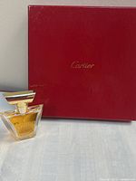Perfume bottle displayed beside Cartier box