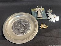 Group shot showing all five items: cherub plate and four pieces of angel jewelry