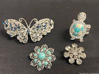 Group shot of all four brooches on black background