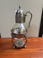 Full view of glass carafe on stand with burner