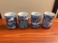 Front view of four Takahashi porcelain tea cups showing differing blue-and-white patterns