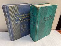 Front covers of both cookbooks standing side by side