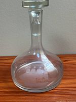 Full view of clear glass decanter with stopper inserted