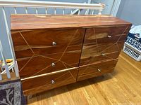 Front view showing six drawers with silver pulls and wood grain pattern
