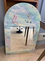 Full view of arched mirror showing hand-painted frame and mirror pane