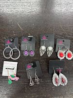 All seven pairs of earrings on display cards