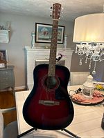 Front view of Fender DG-60/SB acoustic guitar on stand with capo attached