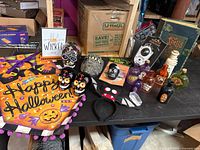 Overview of entire lot on table including banner, skulls, potion bottles, sign, headband, packaged items