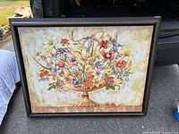 Full view of framed floral canvas leaning against vehicle