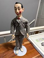 Front view of Pee-wee Herman doll on stand
