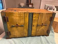 Front view showing yellow and green painted two-door cupboard