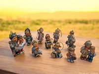 Group shot of all 11 ceramic Hummel ornaments on wood ledge